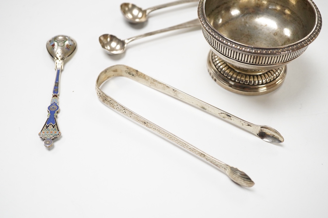 A George III silver pedestal salt, London, 1805, diameter 84mm, together with a pair of Georgian silver sugar tongs, two silver condiment spoons and a Russian 84 zolotnik and polychrome cloisonne enamel spoon, 11.1cm.